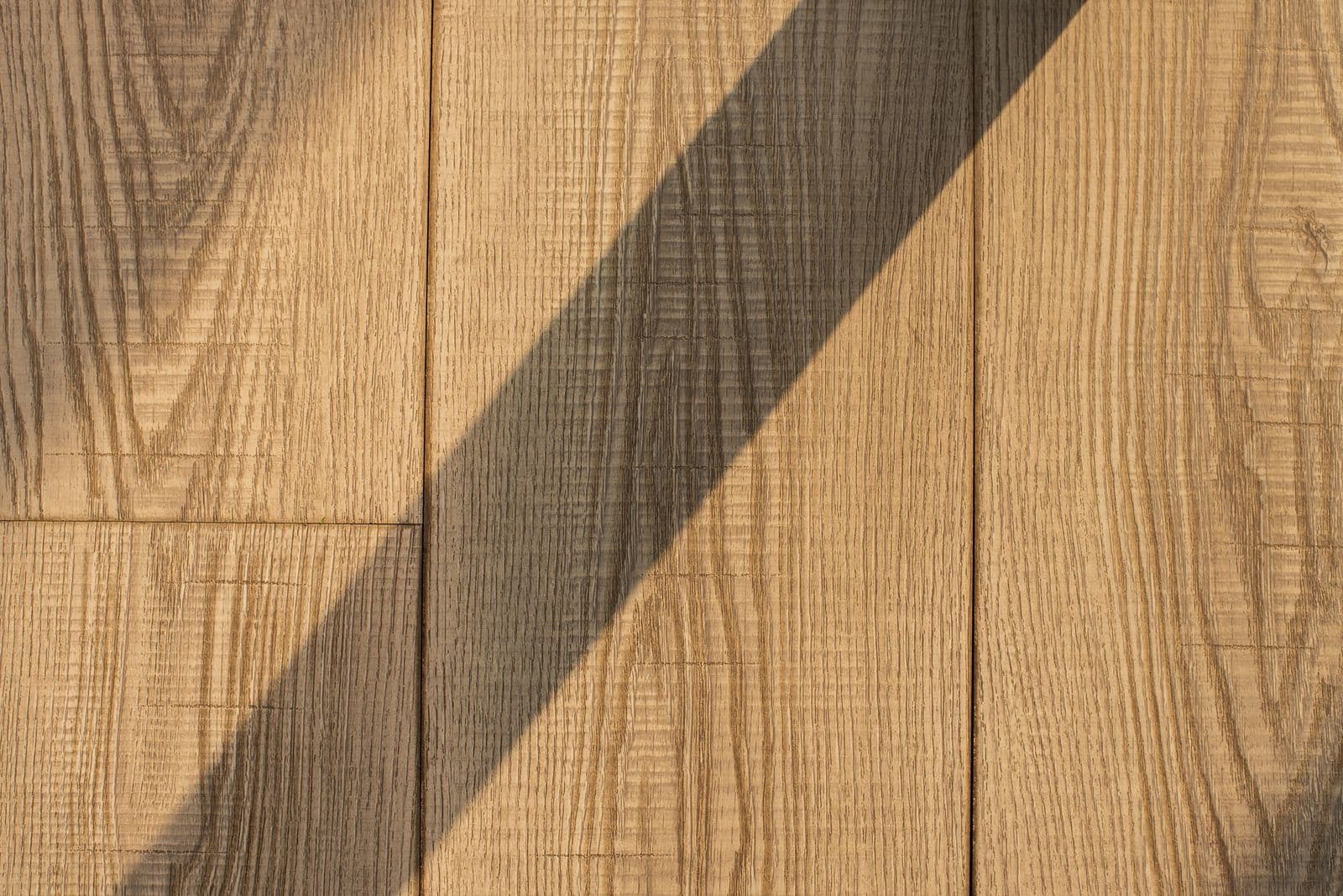 Vertical wood panels crossed by a diagonal shadow