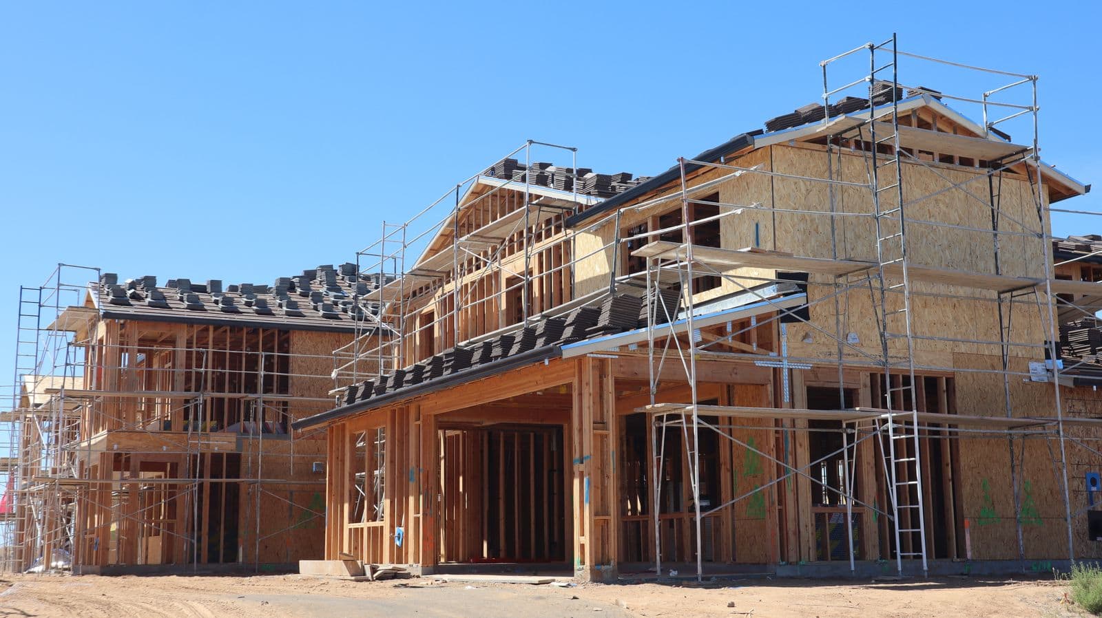 New houses in sheathing with scaffolding along the walls