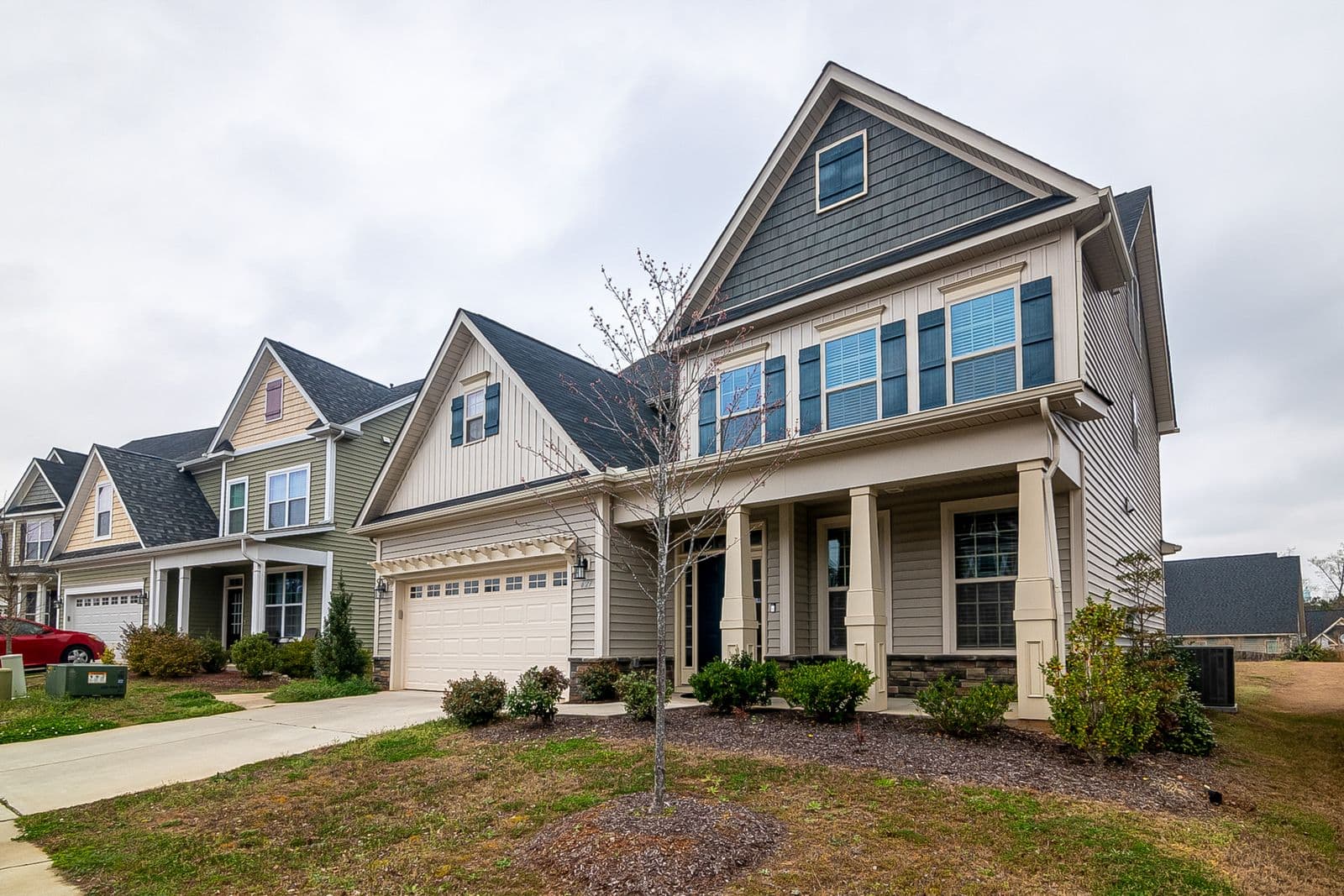 Row of two-story houses with gray and tan siding and front porches