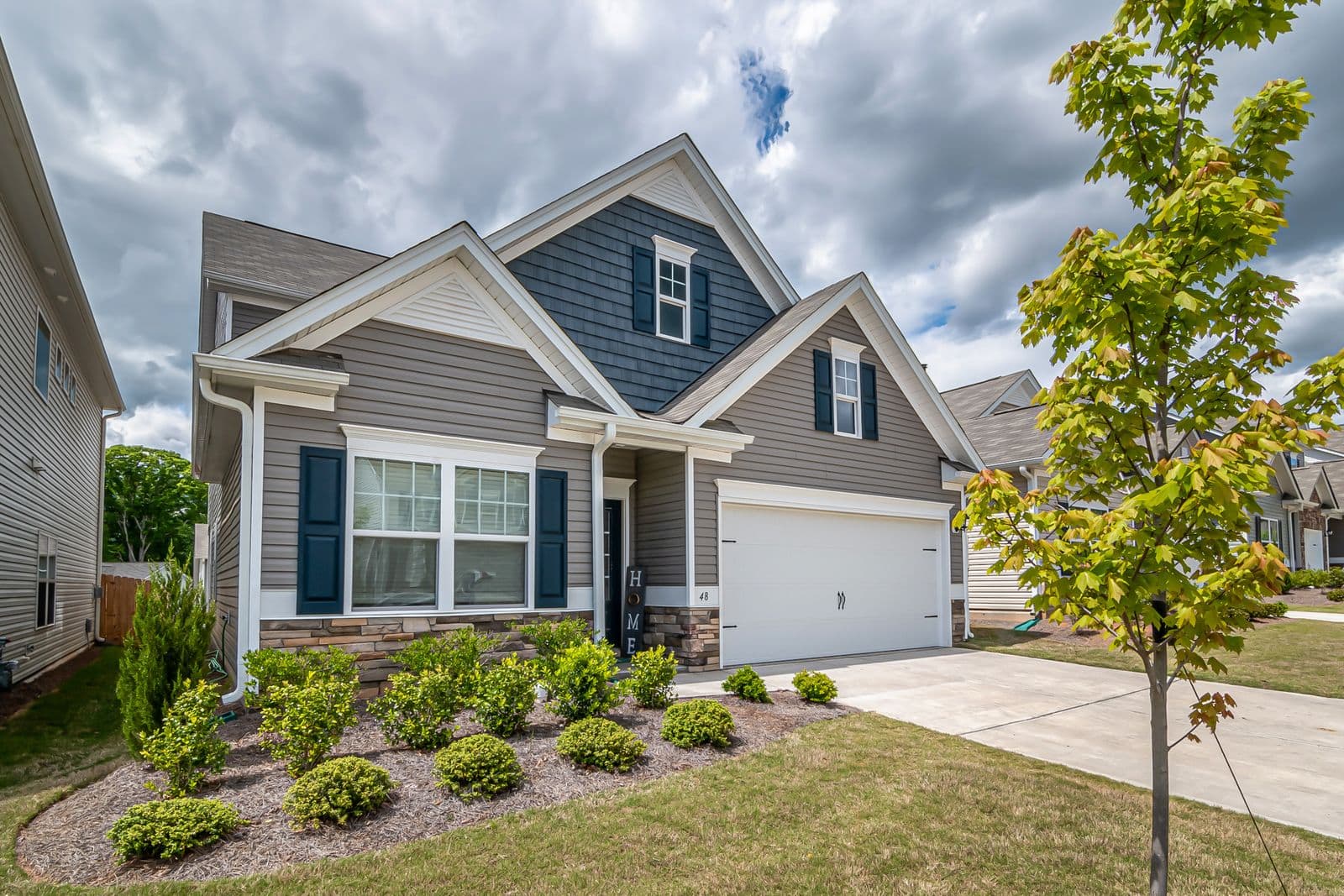 House with gray and white siding and a planted front bed