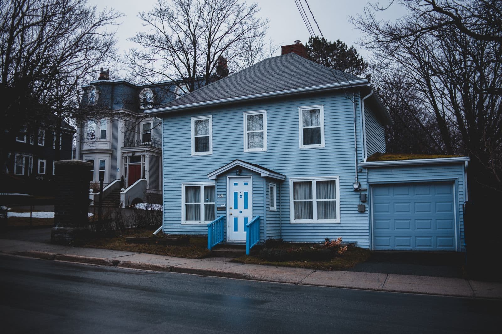 Small house with light blue siding and a matching garage